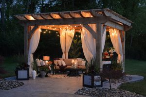 Pergola en bois et en voilage éclairée de nuit